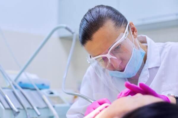 Dentist performing dental checkup on patient in clinic